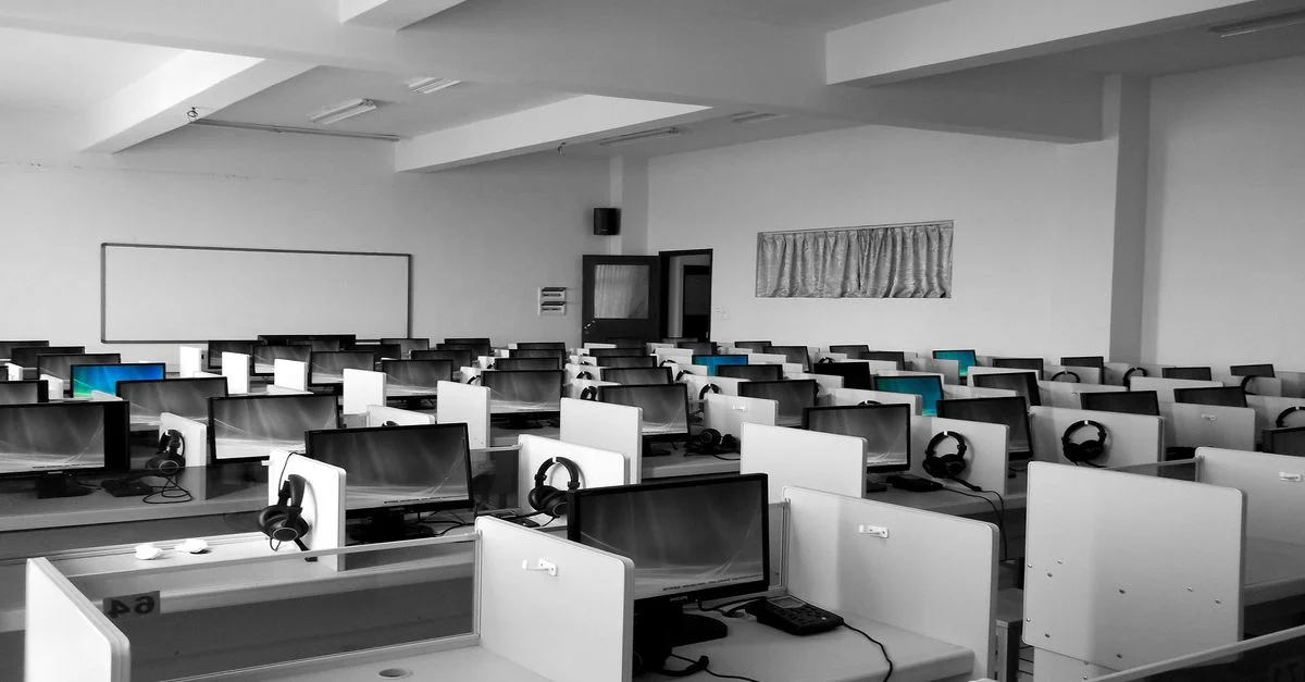 Un bureau de centre d'appel spacieux et vide avec des rangées de bureaux et d'ordinateurs, idéal pour des environnements professionnels.