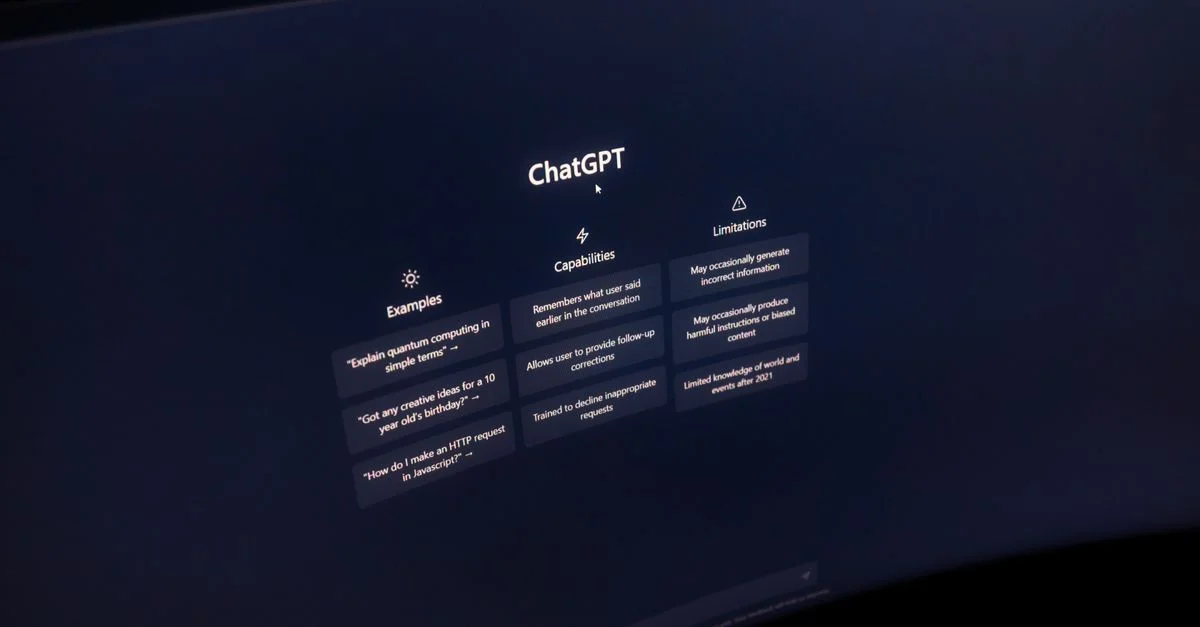 Gros plan sur un écran d'ordinateur affichant l'interface de ChatGPT dans un environnement sombre.
